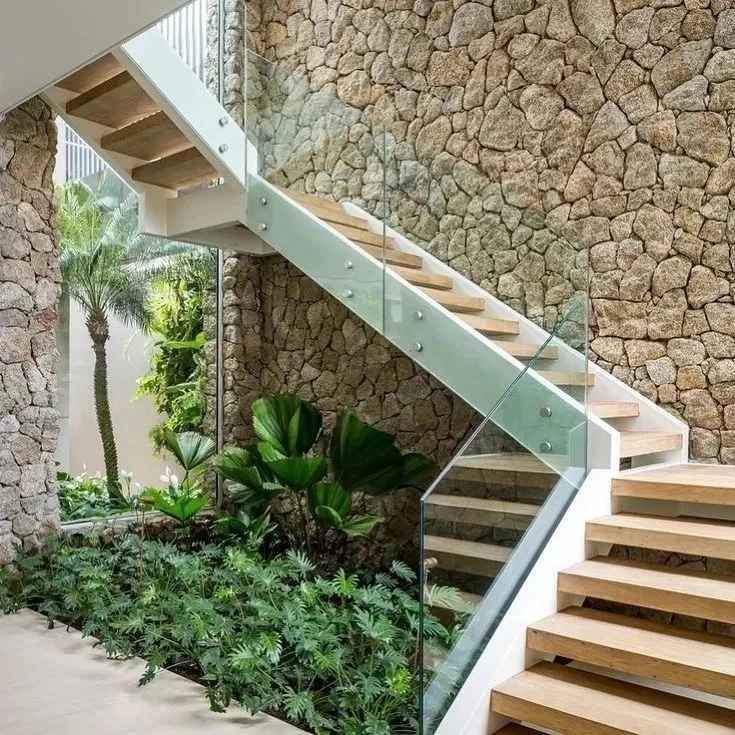 Parede em Pedra Moledo Champagne ao lado de escada com jardim interno