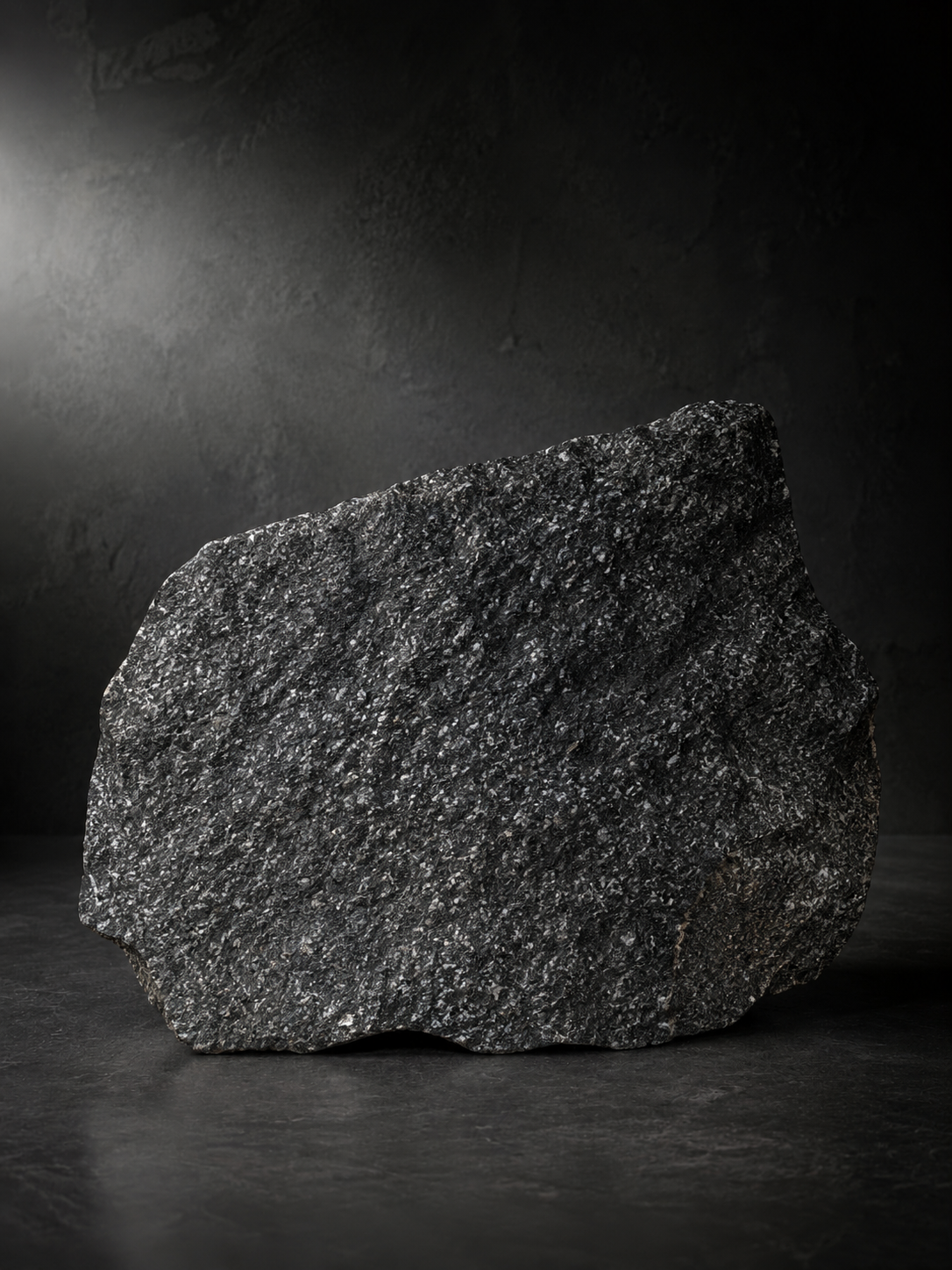 Peça real de Pedra Moledo Black em fundo escuro mostrando a granulação natural