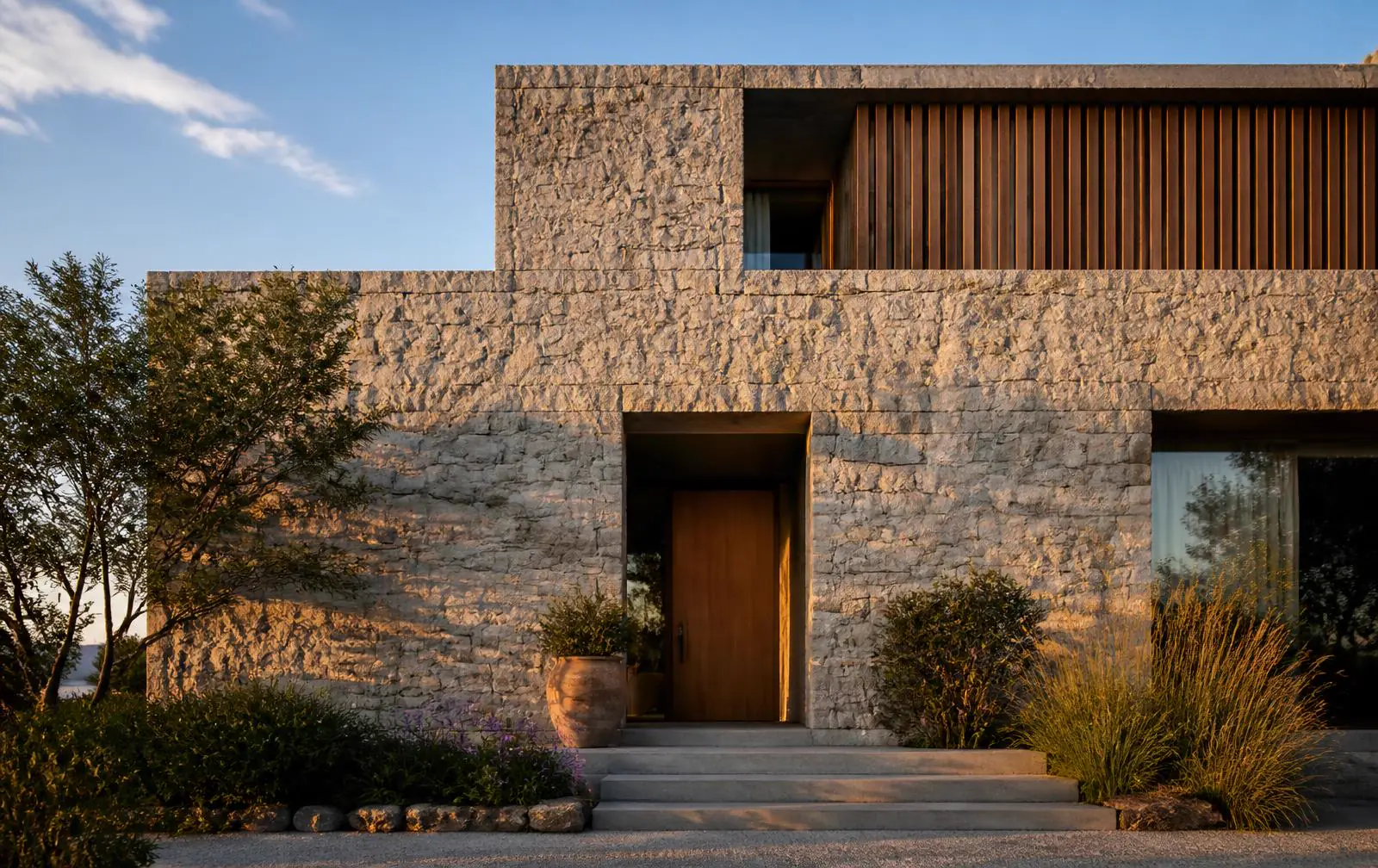 Fachada residencial contemporânea revestida com Pedra Moledo natural de formatos irregulares